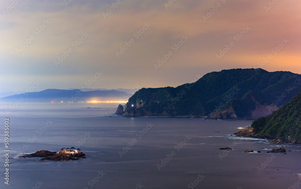 Lights on small rocky island off rugged Sea of Japan coast at night Lights on small rocky island off rugged Sea of Japan coast at night