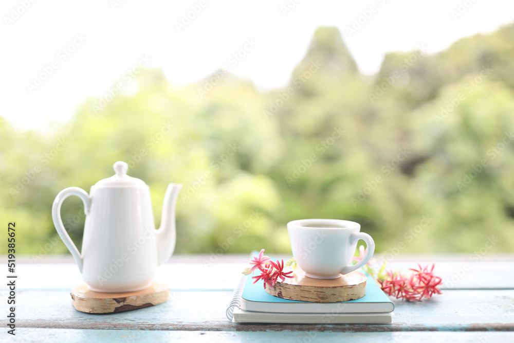 Fototapeta premium White tea cup and vintage tea pot and pink Ladyfinger flowers on wooden table