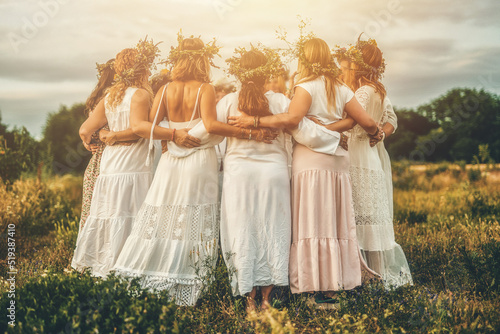 Tableau sur toile Women in flower wreath on sunny meadow, Floral crown, symbol of summer solstice