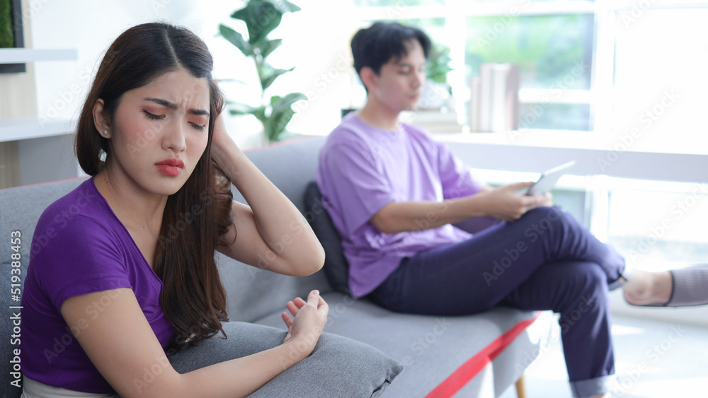young asian woman sitting on the sofa with anger annoyed boyfriend