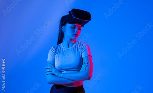 Portrait of young woman with a glasses of virtual reality in neon light. VR, augmented reality, science, future technology concept. Futuristic 3d glasses with virtual projection.