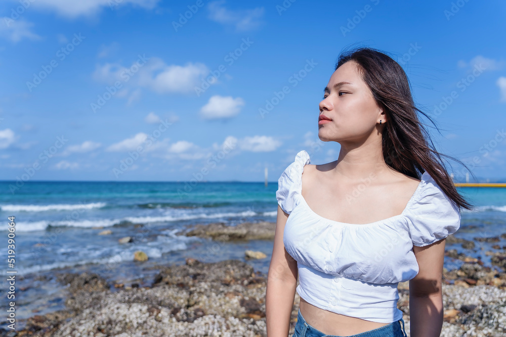 Happy young woman walking on the beach with the wave of sea in tropical ocean background, enjoying the beautiful view of the blue sea. Outdoor summer lifestyle. Vacations and freedom concept. Happy young woman walking on the beach with the wave of sea in tropical ocean background, enjoying the beautiful view of the blue sea. Outdoor summer lifestyle. Vacations and freedom concept.