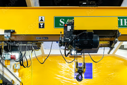 Close up electric over head crane hoist with trolley frame drive unit wire rope hook block for lifting and transfer object and reduce work load photo