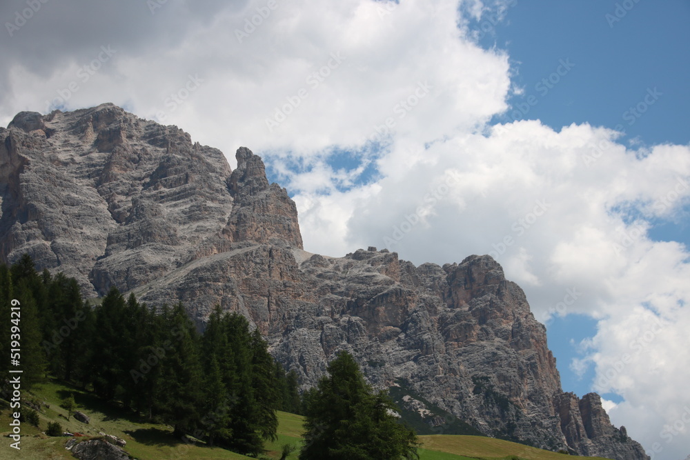 Rock formation with trees in foreground and a cloudy sky