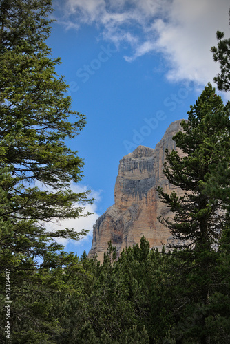 Rock formation with trees in foreground and a cloudy sky © Tobi