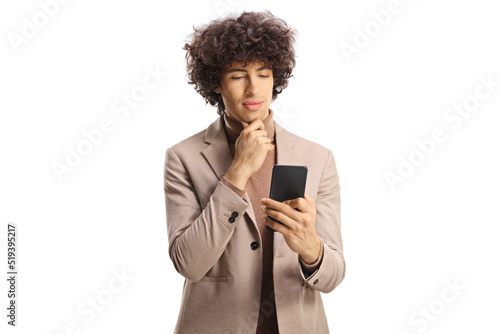 Young man with curly hair lookint at a smartphone photo