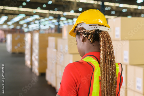 Portrait of young mixed race female worker wearing helmet in modern warehouse storage of retail shop photo