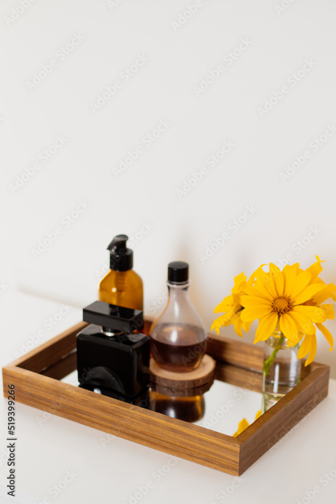 Perfume, wildflower vase, lotion and liquid soap on mirror tray. Aesthetic minimalist bathroom composition. Perfume, wildflower vase, lotion and liquid soap on mirror tray. Aesthetic minimalist bathroom composition.