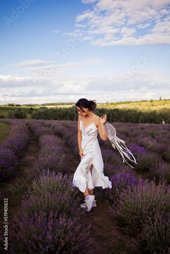 Young pretty asian woman holding dreamcatcher in lavender field.