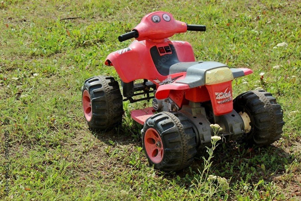 Obraz premium big children's red quad bike on green grass
