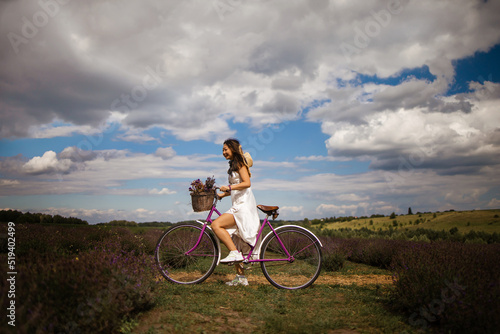 Young asian girl with a bicycle walks on a lavender field.