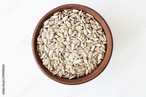 Top view of a pile of natural organic sunflower seeds isolated on white background.