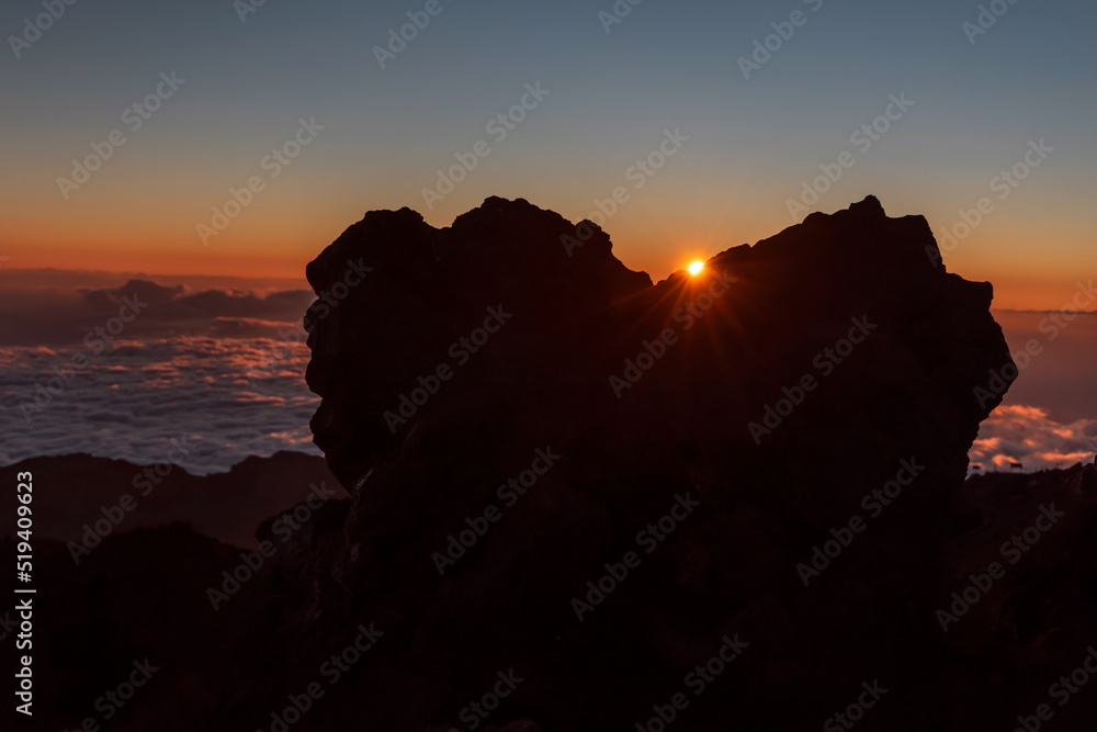 Sunset with a rock formation in a shape of heart above the clouds on the peak of Mount Teide called 'Pico del Teide'. Teide National Park, Tenerife, Canary islands, Spain.
