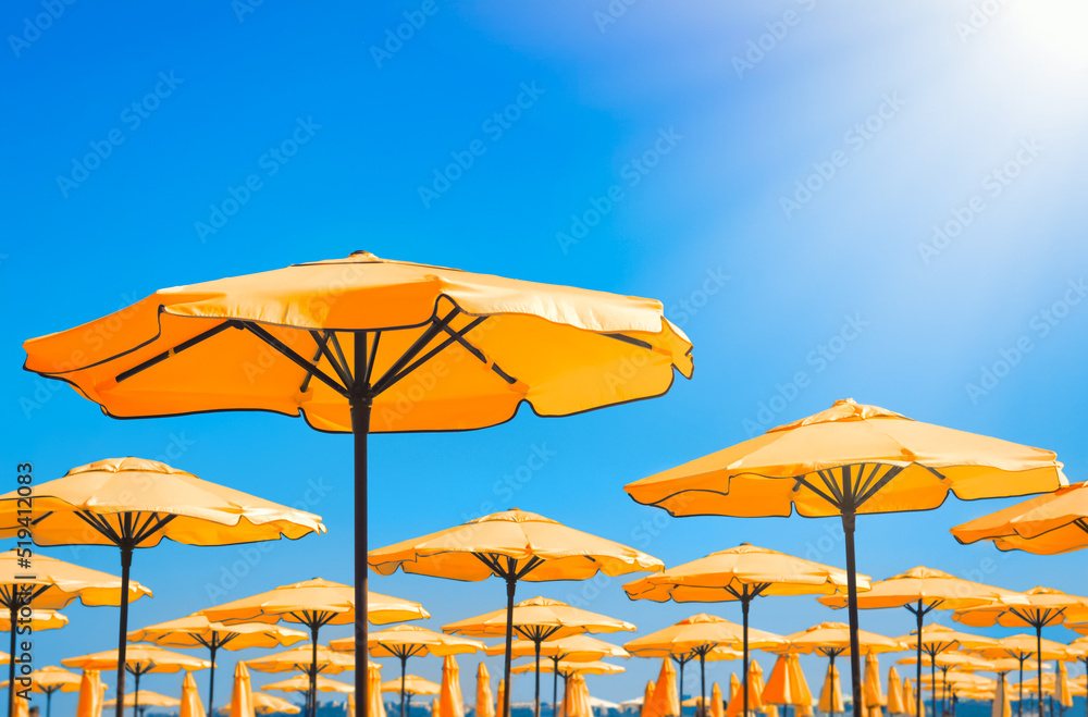 Beautiful orange beach umbrellas against blue sky