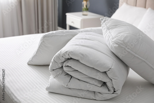 Soft folded blanket and pillows on bed indoors