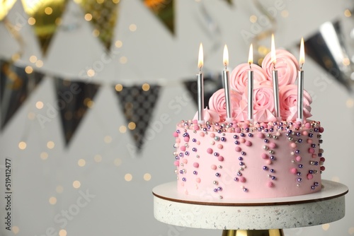 Photography Beautifully decorated birthday cake on stand against blurred festive lights