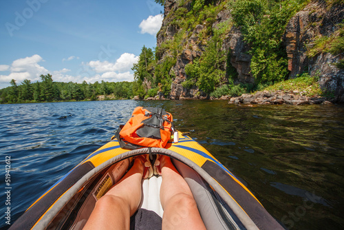 View of a rock face from the perspective of a kayaker in an orange kayak.