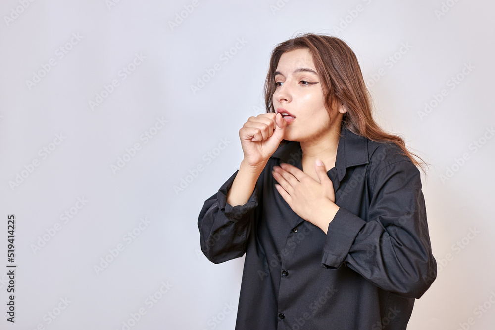 A girl in a black shirt coughs uncontrollably. Cough and cold concept. A girl in a black shirt coughs uncontrollably. Cough and cold concept.