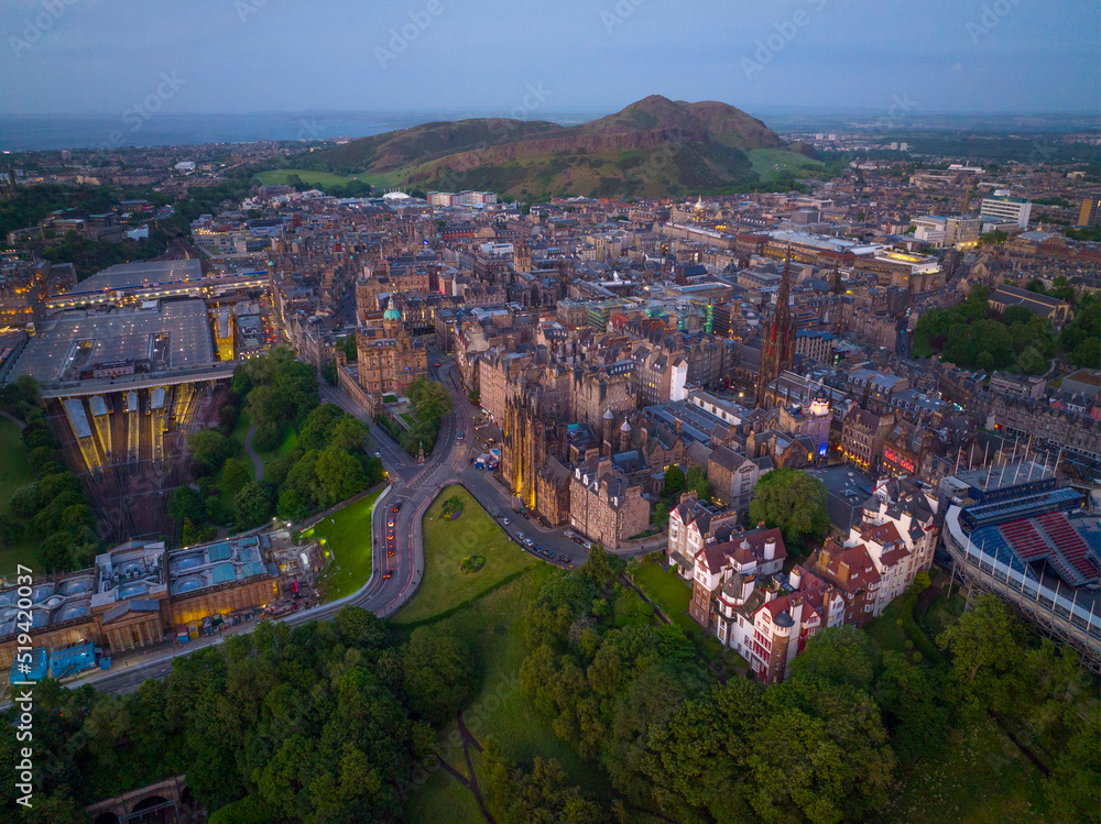 Old Town and Tolbooth Church on Royal Mile aerial view with Holyrood Park at sunset in Edinburgh, Scotland, UK. Old town Edinburgh is a UNESCO World Heritage Site since 1995. 