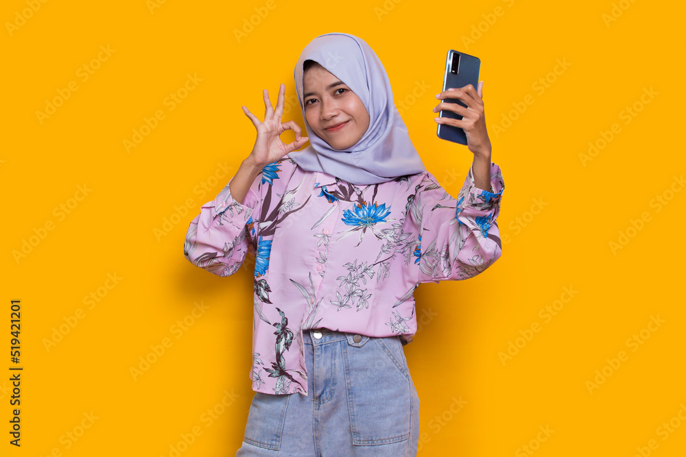 happy young asian beautiful muslim woman using mobile phone isolated on yellow background
happy young asian beautiful muslim woman using mobile phone isolated on yellow background