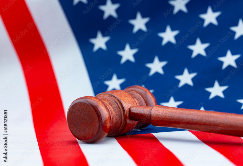 Gavel toppled on American flag displays judicial conflict and fallen justice
