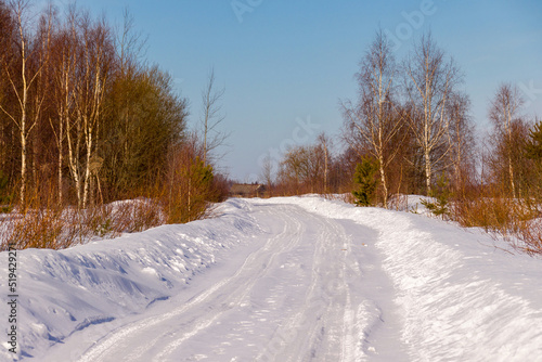 winter road through the forest to the village