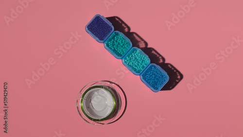 a palette of colored beads in a plastic box and a fishing line on a colored background