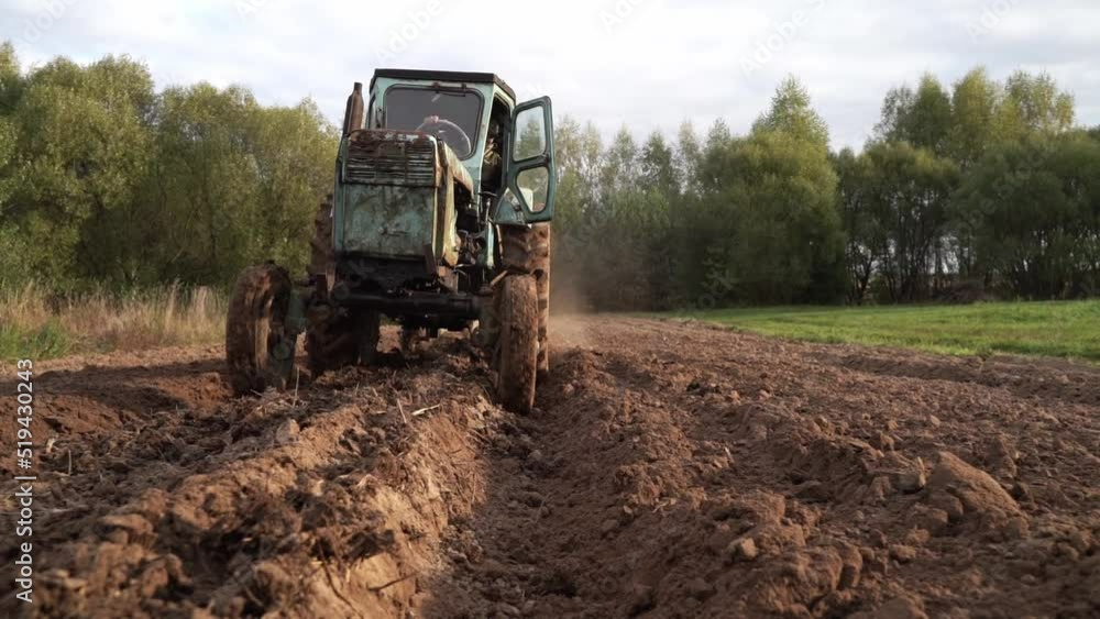 selective focus. a peasant plows the land on a tractor selective focus. a peasant plows the land on a tractor