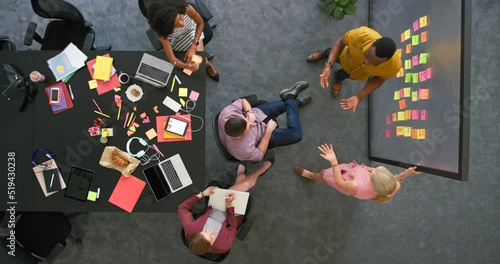 Overhead view of creative team in a meeting brainstorming ideas. Professional colleagues working together to plan a solid marketing strategy. Group in close collaboration inside boardroom photo