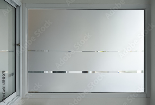 Aluminium sliding window of office. office sliding glass window. Decorative Glass Film on door of office. Closeup Frosted Glass Thick Film for reduced visibility across.
