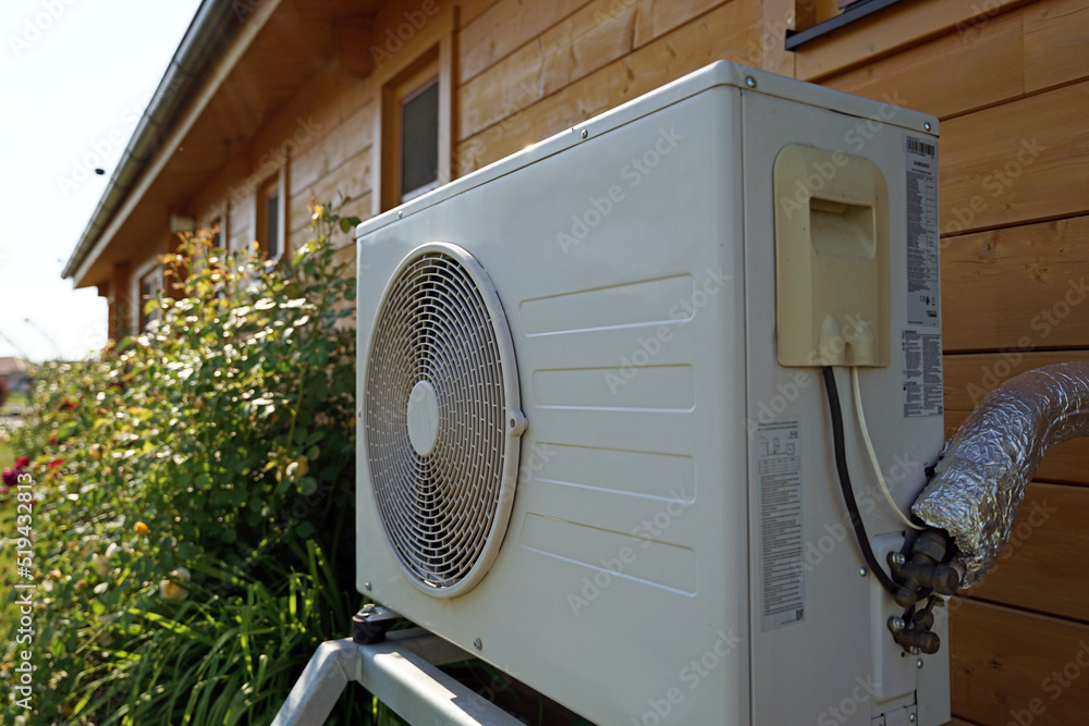 Air condition or heat pump outdoor unit, modern wooden house of future using green electric energy concept
