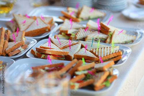 triangular appetizing sandwiches on a plate at an event