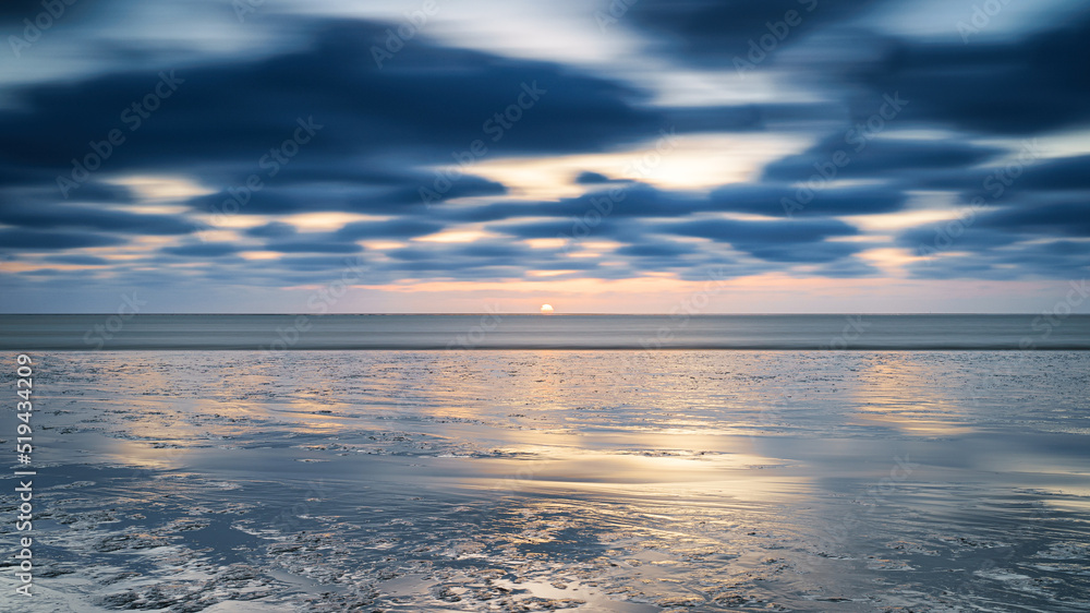 Fototapeta premium Beach at sunset (mud flat ) me passing clouds at mudflats