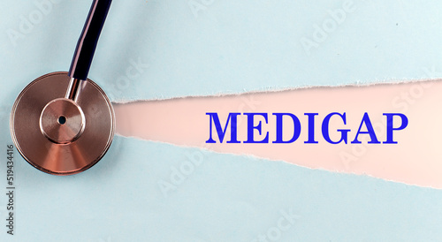 MEDIGAP word made on torn paper, medical concept background photo