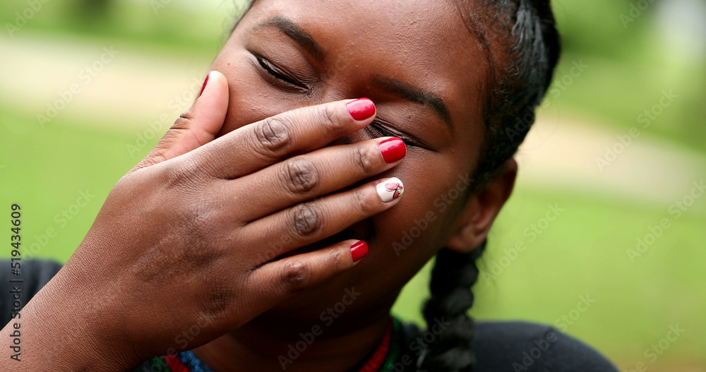Black girl laughing covering face with hand. real life laugh