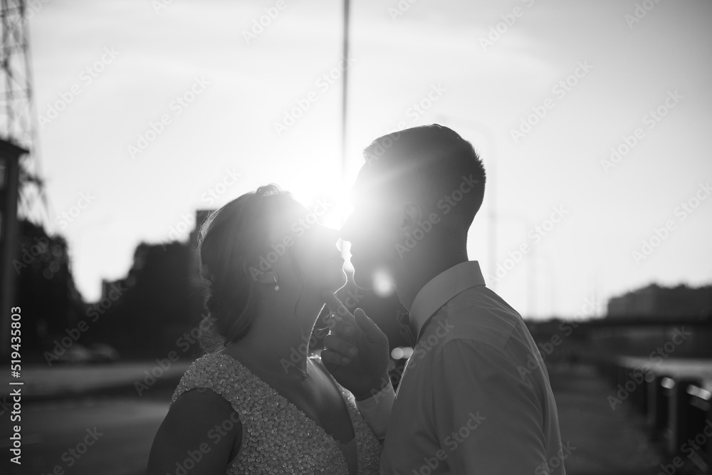 A kiss of the bride and groom at sunset. Wedding article. A happy couple. Love. Photos for printed products.