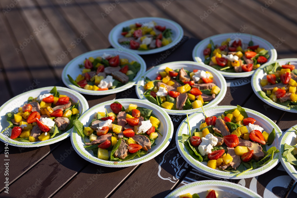 appetizing light salads with strawberries in plates on the table	