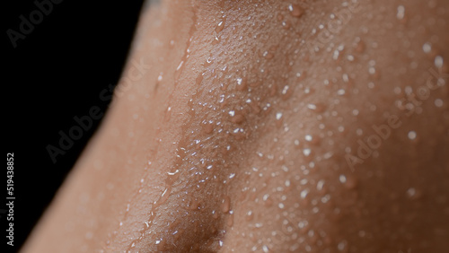 Macro shot of slim white-skinned woman's wet good-looking clean flat belly on black background | Wet skin texture shot for healthy nutrition concept