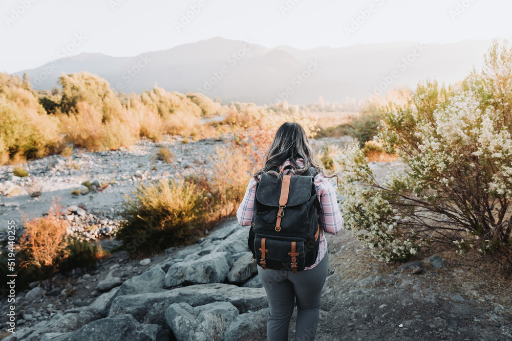 Naklejka premium Unrecognizable woman with a backpack on and a pale pink blouse in nature.