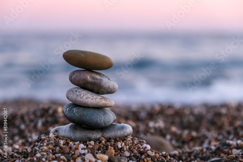 Selective Focus  focused on foreground  pyramid of pebbles on the beach at sunset. Concept of zen  stability  harmony  balance and meditation  copy space. 