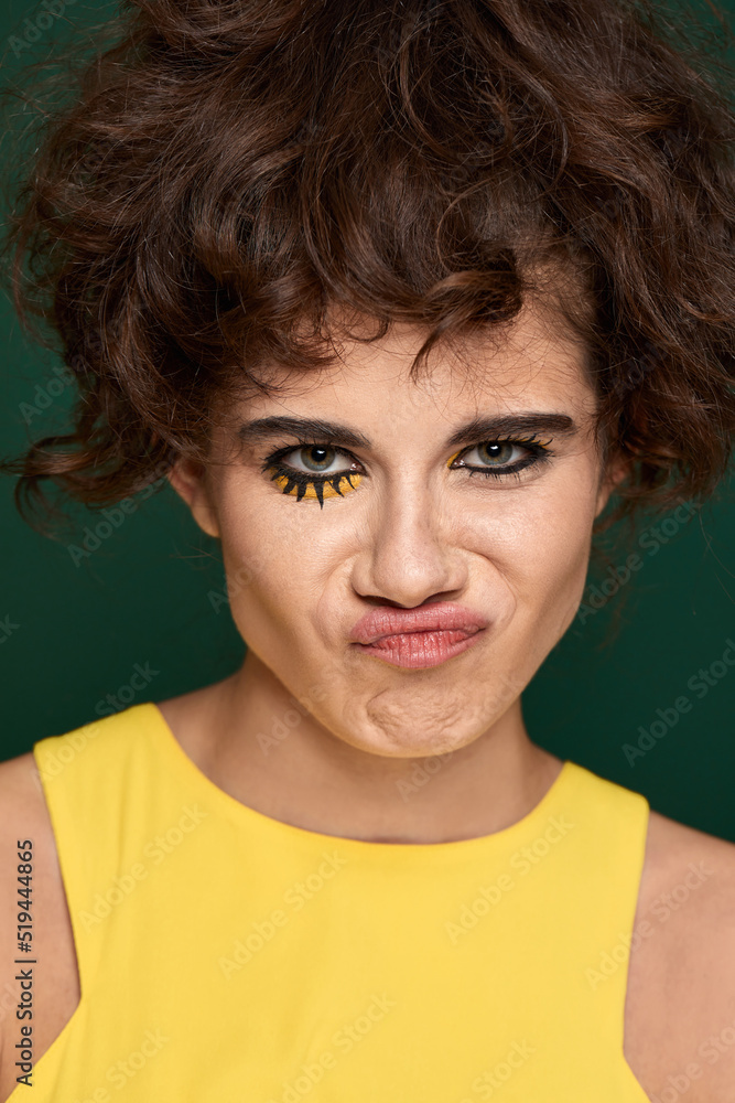 young curly woman with creative make-up in yellow dress young curly woman with creative make-up in yellow dress