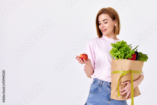 caucasian woman hold paper bag with vegetables