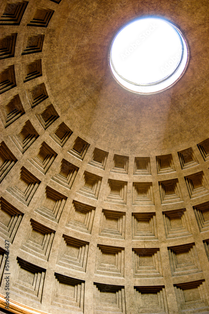The Pantheon Dome in Rome, Italy as the light shines through the oculus a central opening in the roof is a classic architectural design from the Roman Empire rebuilt by Emperor Hadrian.  