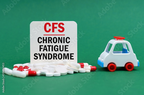 On a green surface, an ambulance, pills and a white sign with the inscription - Chronic Fatigue Syndrome photo