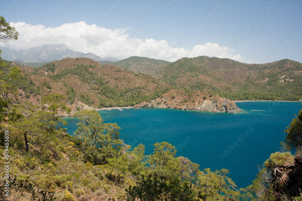 Picturesque landscape. View of Mediterranean Sea from top of hill. Postcard view of sea bay surrounded by mountains and hills. Hike along Lycian Way, Antalya, Kemer, Turkey. Spring