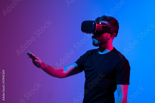 Teen male student use vr glasses and looks at empty copy space. Virtual gadgets for entertainment, work, free time and study. Virtual reality metaverse technology concept.