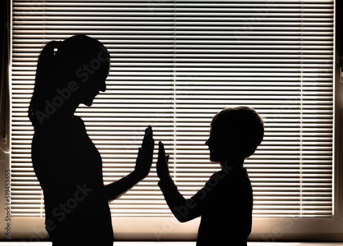 Mother giving her child encouragement and positive support with a high-five. Parenting and teaching concept. 