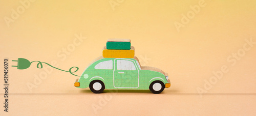 Small green electric car with a cable for recharging, vacation trip with eco power photo