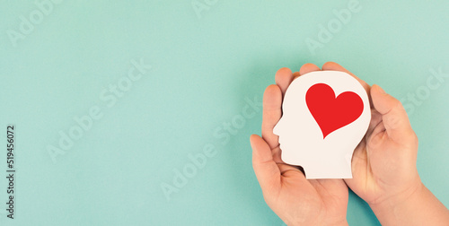 Fotografi Holding a head with a red heart in the hands, symbol of love and positive emotio