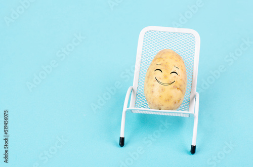 Potato with a funny face is sitting in lounge chairs, happy holiday, greeting card
 photo